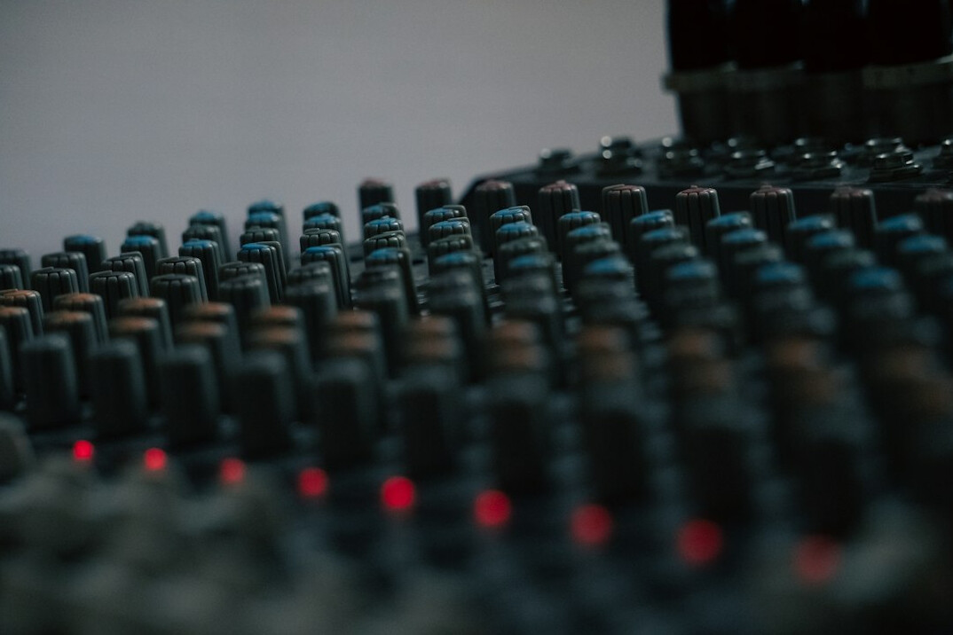 Modern video editing studio interior with multiple monitors and a mixing console